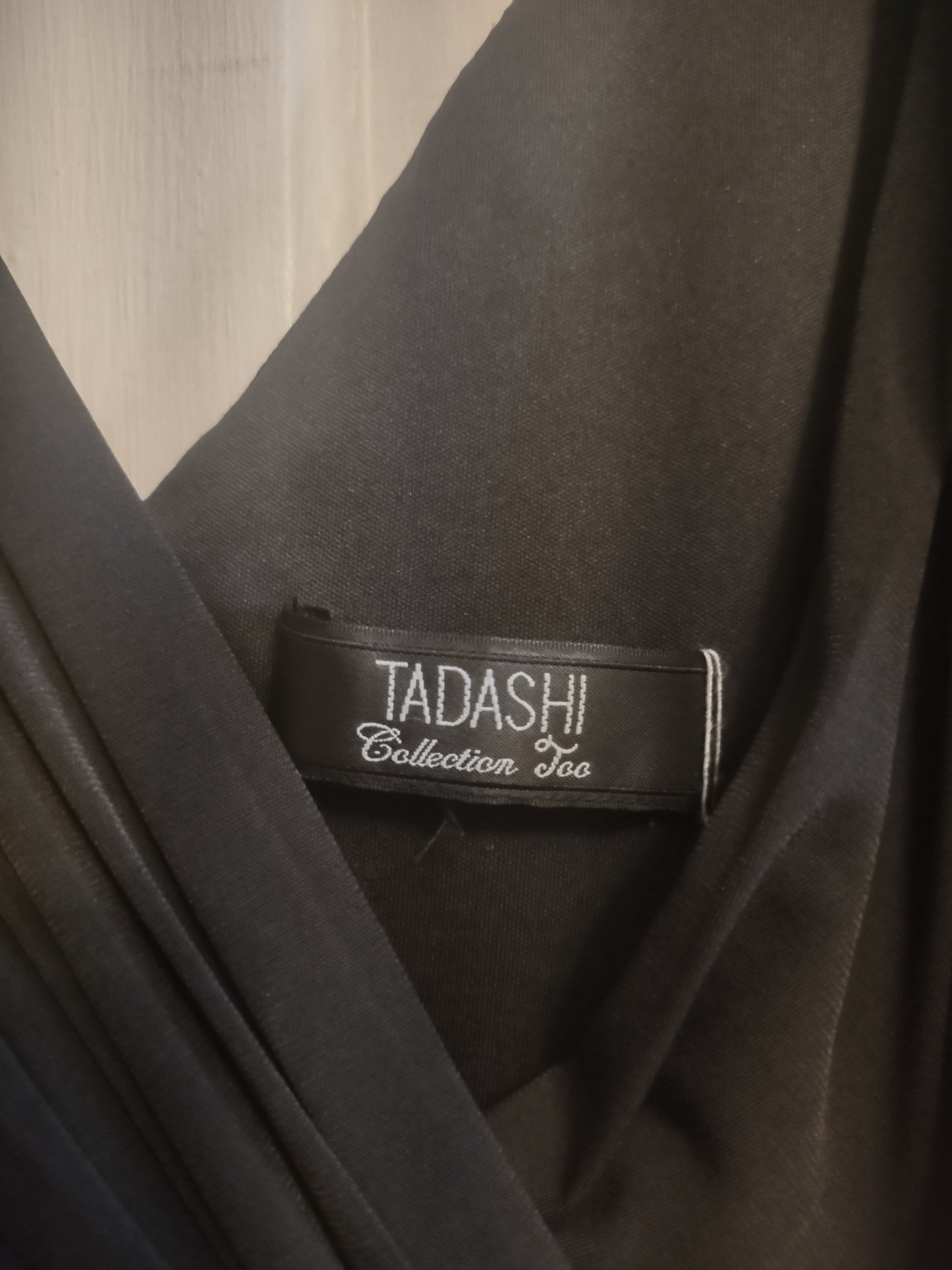 Tadashi Collection label on a piece of dark fabric